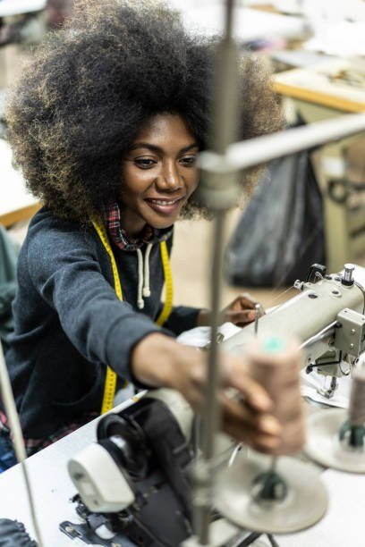 Close-up of hands guiding fabric through a sewing machine